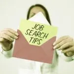 Person holding an open envelope with a card inside that reads 